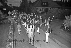 Freiwillige Feuerwehr Zarpen: Fackel- und Laternenumzug: vorn Spielmannszug "Old Reinfelder Jungs": dahinter Kinder mit Laternen und Erwachsene: rechts und links Mitglieder der Jugendfeuerwehr und Kinder mit Fackeln: Abend