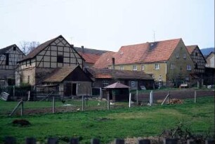 rückwärtige Hofansicht: Wohnhaus und Scheune stehen parallel, dazu kleinere Wirtschaftsgebäude und Geflügelställe; Garten