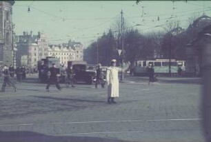 München. Verkehrspolizist auf der Kreuzung Prielmayerstraße/Ecke Karlsplatz beim Regeln des Verkehrs, rechts Justizpalast