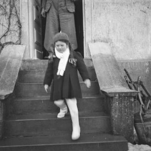 Mädchen in Winterkleidung geht eine Treppe hinunter