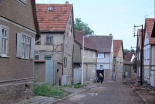 unbefestigte Dorfstraße mit kleinen Höfen, Häusern