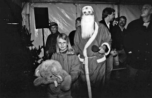 Weihnachtsmarkt am Schloss: Bürgermeister Klaus Boenert als Weihnachtsmann verkleidet übergibt einen Stoff-Elefanten