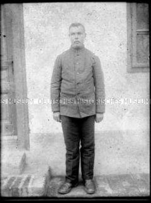 Soldat vor einer Hauswand, 1. Weltkrieg