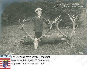 Wilhelm Kronprinz v. Preußen (1906-1940) / Porträt mit Hirschgeweih (Jagdtrophäe seines Vaters) vor verendetem Hirsch stehend, Ganzfigur