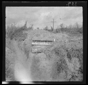 [bei Arras (Dep. Pas-de-Calais, Frankreich):] 2 Orientierungsschilder am Schützengraben "Obermayer-Graben", im Hintergrund mit Soldatengrab [aus französischen Blindgängern erbaut?]