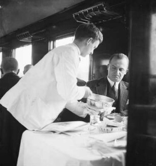 Kellner beim Servieren im Mitropa-Speisewagen : Deutsche Reichsbahn. Kellner beim Servieren im Mitropa-Speisewagen