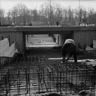 Konrad-Adenauer-Ring: Unterführung am Exer: Bauarbeiten: Blick auf Baustelle mit Holzverschalungen, Eisengittern und Bauarbeiter: im Hintergrund Bäume, Baukräne und Gebäude