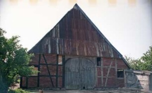 Freestot 10: Bauernhaus: Giebelseite Wirtschaftstrakt mit Blechdach und Scheunentor, verfallen