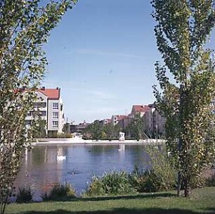 Hansjakob, Gottfried; München - Schwabing, Berliner Str.; Wohnanlage an der Berliner Straße (Schwabinger See) - Nordöstliches Ufer, Blick in Schinkelstraße, Uferpromenade mit Steinskulptur 'Hockende' (Wilhelm Uhlig, 1986)