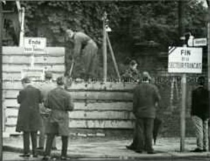 Ein Arbeitskommando der Grenztruppen begradigt einen Mauerabschnitt an der Bernauer Straße
