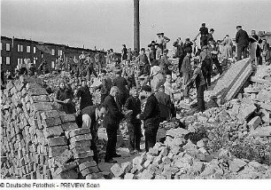 Dresden. Einwohner beim Bergen wiederverwendbarer Ziegel aus einem Trümmerberg und Verladen auf Lastkraftwagen bzw. Stapeln