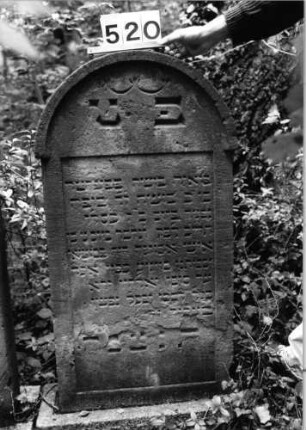 Grabstein 520 (Index: 99802704) Material: Sandstein Zustand: unten abgeblättert Maße HxBxT: 128x57x10 cm Beschreibung: Sock/Stele mit verdachtem Rundbogen, profiliertem Rand: Grabstein 520