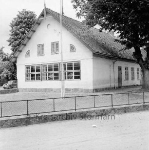 Schulen: Volksschule an Kirchenstraße: davor Fahnenmast, Baum, Zaun