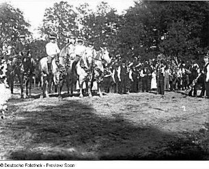 Fest der Landleute. Geschmückte Pferde mit Reitern und Bauern, die auf Beginn des Festumzugs warten