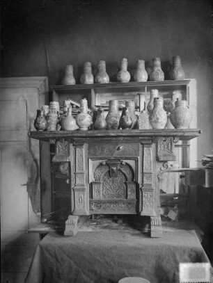 Geschnitzter Schrank mit Krügen