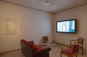 Dresden. SLUB. Ausstellung "Geteilte Erinnerungen. Das Fotoalbum - gesteckt, geklebt, gepostet" im Buchmuseum. Sitzgruppe zur Filmvorführung (Blättern in Albenauswahl) im Eingangsbereich
