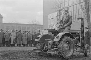 Ein Messebesucher testet auf dem Außengelände einen Allgaier-Porsche-Diesel-Schlepper der Firma Porsche-Diesel-Motorenbau GmbH
