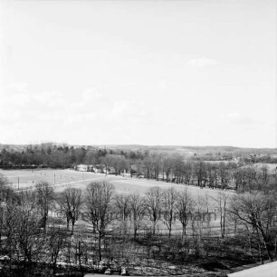 Vogelperspektive: von Silo der Weizenmühle ("Gloria-Mühle") der Johannes Ströh Mühlenwerke am Pferdemarkt: Blick nach Westen: Bürgerpark, Exer, Fußballspiel: hinten Gebäude der ehemaligen Flussbadeanstalt, Jugendheim, Trave, Fußgängerbrücke: im Vordergrund Uferweg
