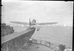 Menschenmenge an Bord des Hochseepassagierdampfers "Bremen" beobachtet den Start des Katapultflugzeugs HE 12 D-1717
