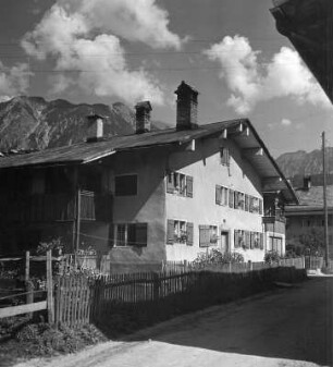 Wohnhaus gegen Gebirge (wahrscheinlich im Allgäu)