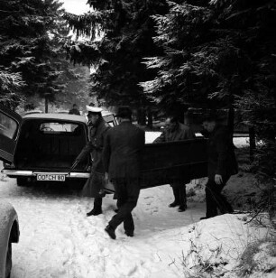 Polizei: Mord an der Hamburger Küchenhilfe Edeltraut Harloff am 26. November 1965: Oher Tannen: Leichenfundort zwischen Tannen und Totholz: Abtransport der Toten: links Leichenwagen mit geöffneter Hecktür: rechts davor zwei Bestatter sowie Polizisten mit Holzsarg: hinten Tannen: Winter