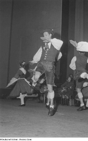 Tanzende Menschen in Tracht bei einer Veranstaltung zum Gedenken an die Völkerschlacht, im Hintergrund ein Orchester