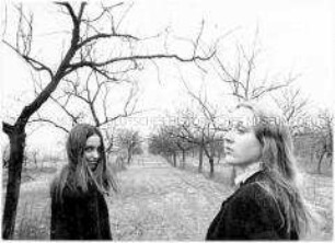Zwei junge Frauen auf einer Obstbaumwiese, die Bäume sind kahl (Altersgruppe 14-17)