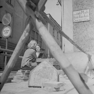 Junges Paar auf Gehwegplatten sitzend, 1970er Jahre. SW-Foto © Kurt Schwarz.