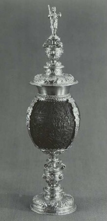 Kokosnußpokal mit Deckel und figürlicher Schnitzerei, auf dem Deckel weibliche Gestalt mit Lanze