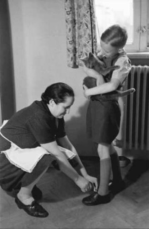 Bukarest: Familie Schmidt [Sohn mit Haushälterin beim Schuhebinden]