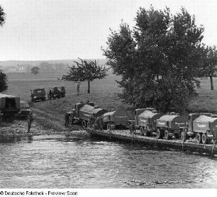 Deutschland . Nationale Volksarmee - Landstreitkräfte. Taktische Übung der Pioniertruppen. Kraftfahrzeugkolonne (Tankwagen vom Typ G 5 mit Anhänger) auf einer Pontonbrücke