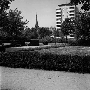 Kurpark: Hecken, Blumenrabatten und Bänke: hinten rechts Hochhaus "Liebe" an Kurparkallee: hinten Mitte Turm der Peter-Paul-Kirche