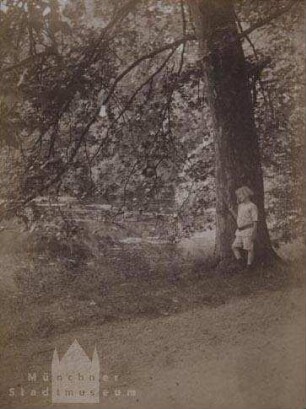 Person im Park, an einem Baum stehend