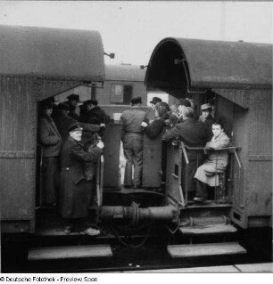 Leipzig. Hauptbahnhof. Mit Reisenden dicht besetzter Perron eines 2-achsigen Einheitspersonenwagens/Personenzug mit offenem Übergang. Baujahr ab 1927