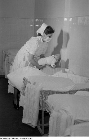 Krankenschwester mit Neugeborenem auf der Säuglingsstation