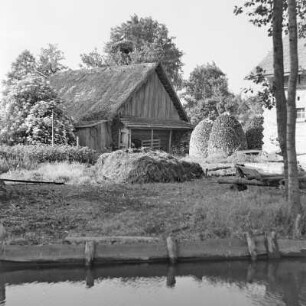 Blick auf ein mit Strohgedecktes Blockhaus mit Storchennest. : Wid na ze słomu pokrytu kładźitu chěžu z baćonjacym hnězdom.