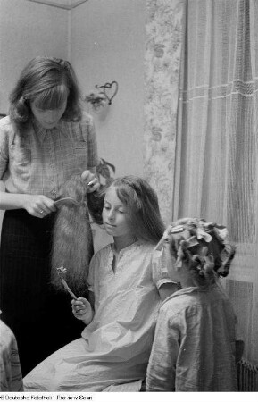 Renate Rössing kämmt einem Mädchen das Haar