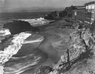 Am Strand : Blick auf Brandungswellen und das Cliff House, ein Hotel, am Strand von San Francisco