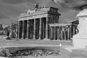 Berlin. Blick über die zerstörte südliche Springbrunnenanlage am Hindenburgplatz nach Nordosten zum Brandenburger Tor