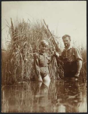 Königswartha, Rudolf Zimmermann mit einem Jungen : Königswartha. Rudolf Zimmermann mit einem Jungen an einem Fotoversteck aus Schilf in einem Teich stehend