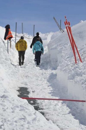 Zermatt - Schneeberge auf dem Gornergrat : Touristen gehen zum Aussichtspunkt auf dem 3089 m hohen Gornergrat durch meterhohe Schneeberge. Aufgenommen am 17. Mai 2010 bei Zermatt