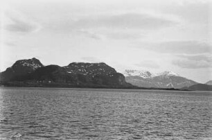Norwegische Küste : Blick auf die norwegische Küste mit einem Felsmassiv am Ufer.
