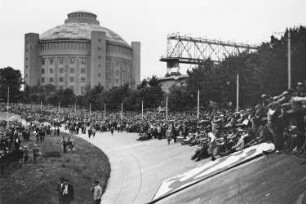 Blick in die Radrennbahn in Reick während einer Wahlveranstaltung der KPD, im Hintergrund das Gasometer Reick