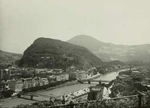 Salzburg, Kapuzinerberg : Salzburg. Blick nach Osten über die Salzach zum Kapuzinerberg mit dem Kapuzinerkloster. Links unten die Brücke ist der damalige Makartsteg (heute Marko-Feingold-Steg), daneben das damalige Hotel Österreichischer Hof (heute Hotel Sacher Salzburg), die nächste Brücke rechts ist die damalige Stadtbrücke (heute Staatsbrücke) und ganz im Hintergrund über die Salzach spannt sich der Mozartsteg