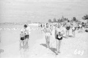 Touristen in Badekleidung am Strand