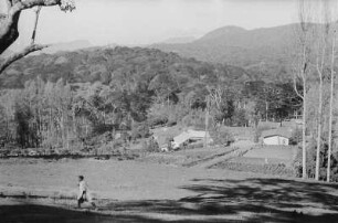 Dorfbild : Blick auf ein Dorf in dessen Hintergrund sich die Usambara-Berge erheben.