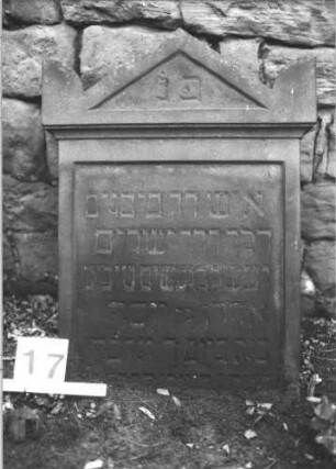 Grabstein 17 (Index: 100105956) Material: Sandstein Zustand: eingesunken Maße HxBxT: 56x55x21 cm Beschreibung: Stele, Giebel mit Eckakroteren, Schriftfeld eingetieft: Grabstein 17