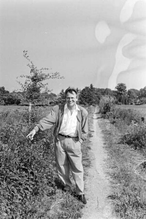 Hof von Günther Fielmann: Besitzer steht auf Feldweg und zeigt mit dem Finger auf etwas