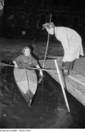 Eine Frau im Kajak legt an einem Steg an