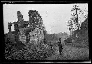 Nicht identifizierbare Ortschaft bei Inchy oder Mœuvres (beide Dep. Nord, Frankreich): "zerstörtes Haus" an einer gepflasterten Straße, darauf ein Wagenkarren, ein Reiter und ein Soldat mit Stahlhelm (Rückansicht, Distanzaufnahme)